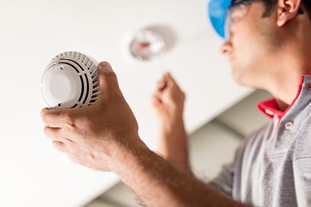 Someone inspecting a carbon monoxide alarm