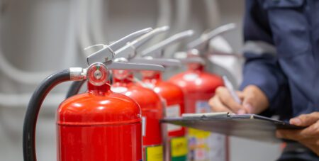 Engineer are checking and inspection a fire extinguishers tank in the fire control room for safety training and fire prevention.