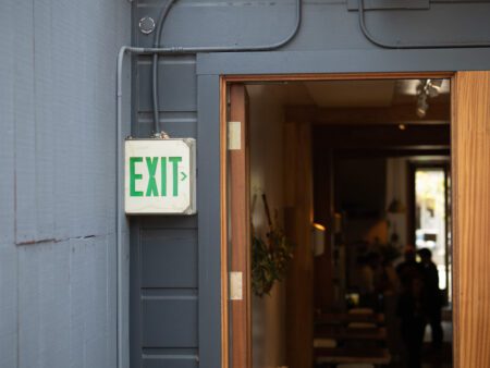 Outdoor green exit sign leading to inside a building restaurant
